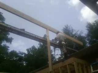 Carpenter setting a ridge beam over a new addition frame — Ice Dam Removal by Roofing Brothers in South Fork
