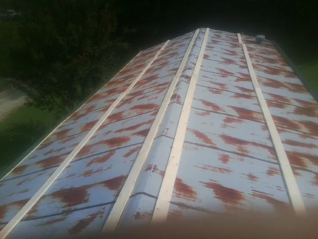 Rusted metal roof panels with new wood purlins before replacement — Storm Damage Roof Repair in South Fork by Roofing Brothers