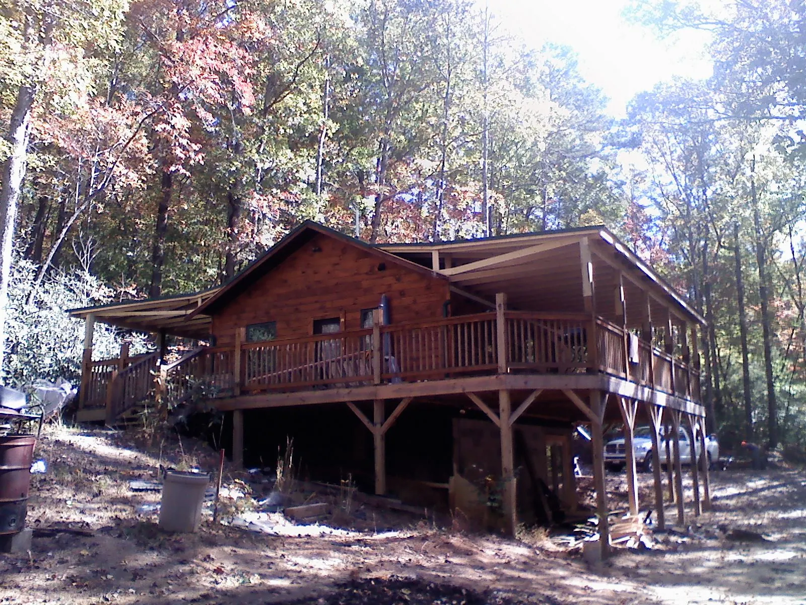 Log cabin with a wraparound porch and metal roof in the fall in South Fork