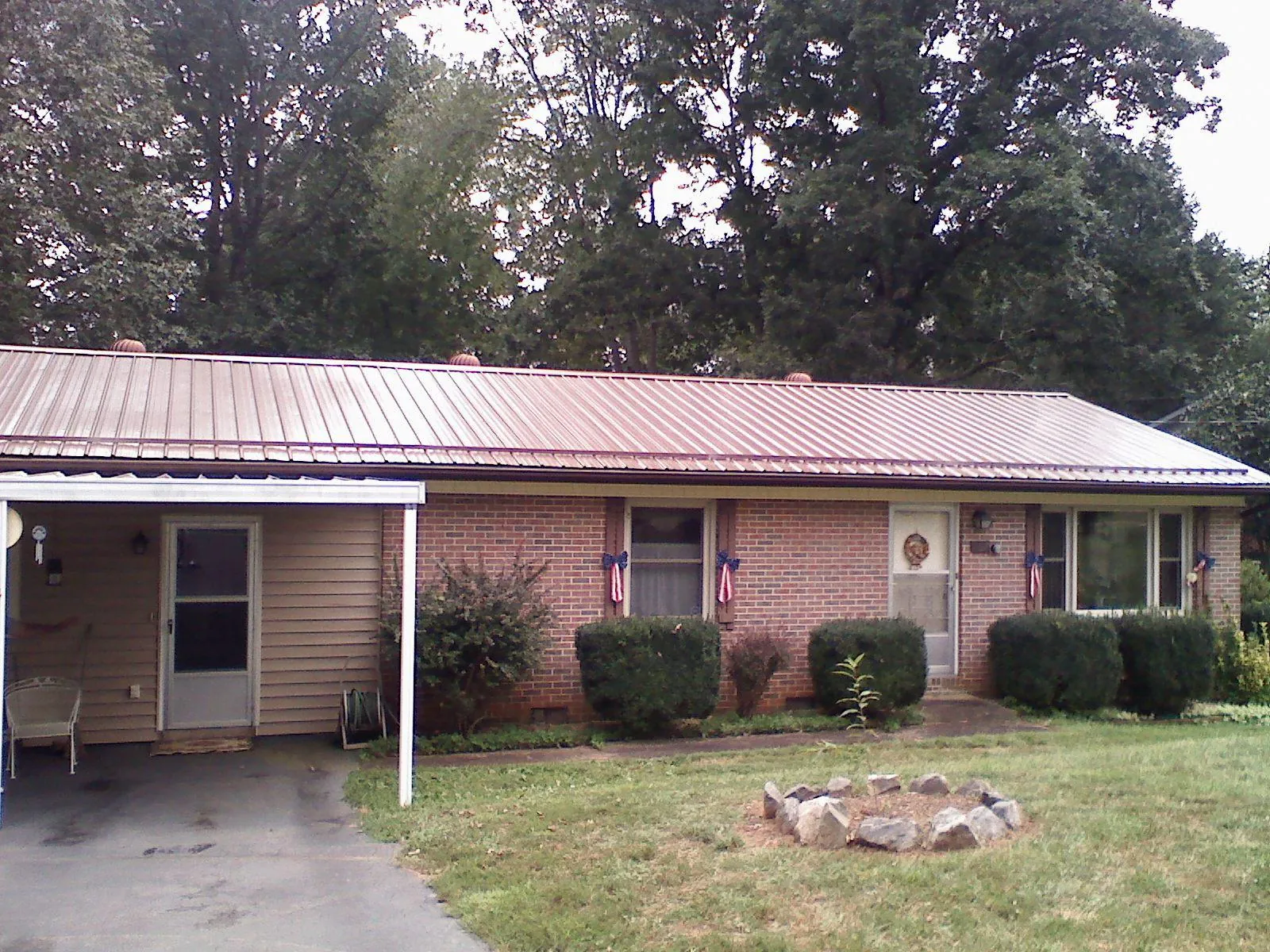 Bronze metal roof and carport on a brick ranch home — Roof Repair work by our crew in South Fork